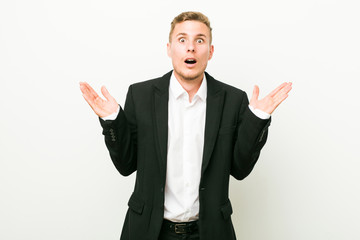 Young caucasian business man surprised and shocked.