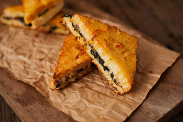 Baked spinach and ham sandwich with sauce.