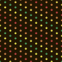 Fototapeta na wymiar Marijuana leaf seamless pattern. Jamaica and african flag colors leaves on black background.