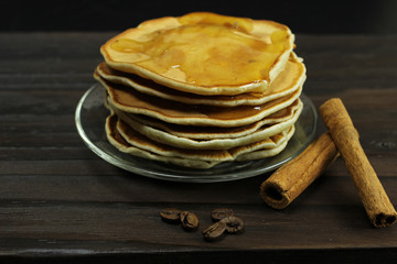 stack of pancakes with honey on a black background