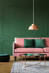 Trendy green living room with pink velvet sofa