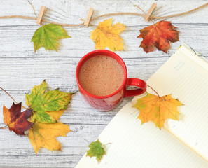 Cup of cocoa with autumn leaves abstract still life. Space for text