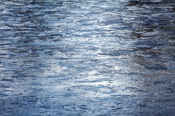 Dark blue ice on the lake. Blurred abstract winter background. Ice skating season