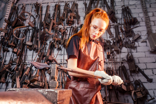 redhead ginger woman blacksmith portrait in workshop