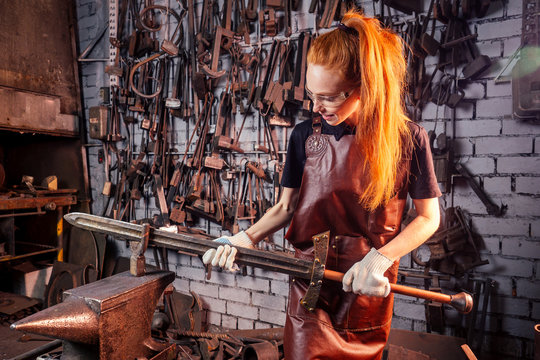 redhead ginger woman blacksmith portrait in workshop
