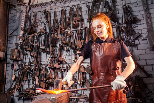 redhead ginger woman blacksmith portrait in workshop