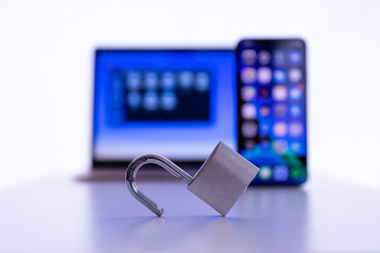 Privacy and data protection: Laptop and smartphone with unlocked padlock