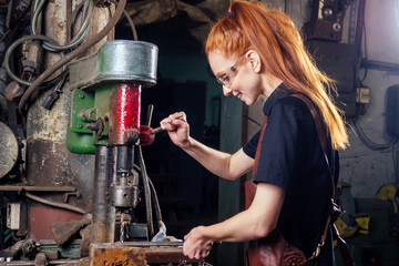 redhead ginger woman blacksmith portrait in workshop