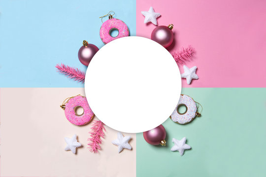 Multicolored paper background in pastel colors with Christmas decoration balls, donuts and stars.   flat lay, top view. Christmas card conception. 