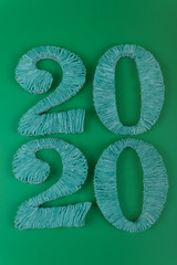 on a green background close-up shows the numbers two thousand and twenty, decorated with strips of fabric