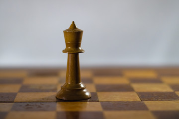 Chess pieces on a chess board in dramatic lighting.