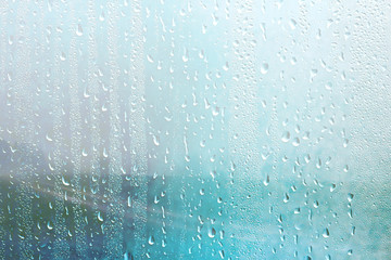 summer rain wet glass / abstract background landscape on a rainy day outside the window blurred background