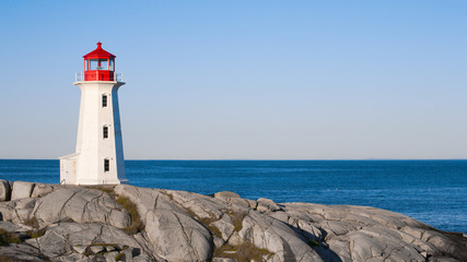 Peggys Cove lighthouse on a sunny day with blue sky. - Powered by Adobe