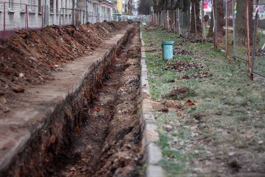 replacement of pipes on the street trench. open ground asphalt. perspective. © evgris