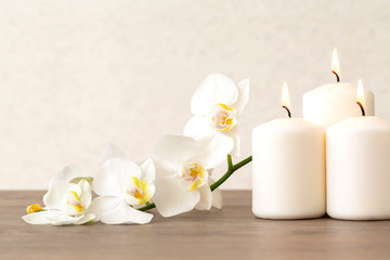 Spa still life with flowers orchids and burning aromatic candles. Copy space. White flowers of...