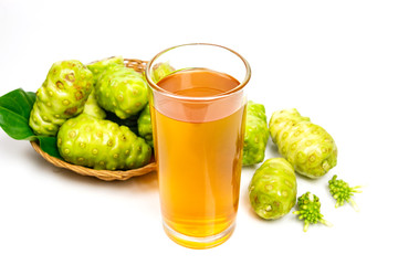 Noni fruit and noni juice in glass isolated on white background.