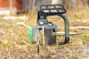 electric chain saw on a background of autumn grass.