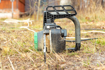 electric chain saw on a background of autumn grass.