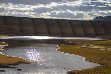 Dam and a small lake in an arid dried out ground.