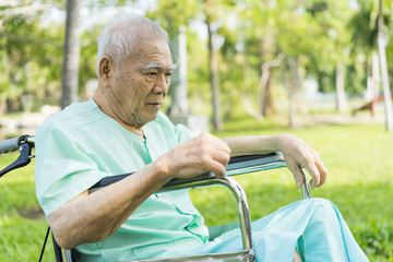 Portrait of an Asian elderly lonely man with Depression or Alzheimer's sadly looking always. A disabled man is sitting in a wheelchair.Concept of memory loss and dementia disease and mental problems