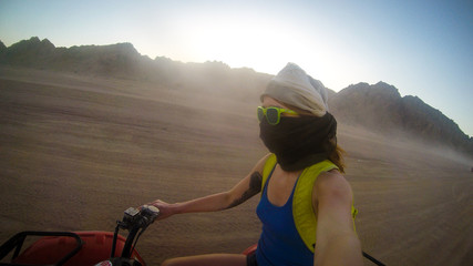Girls drive quad biike.Desert in Egypt. Sharm el Sheikh. Sand and Sand Borkhan. Rock and sunset....