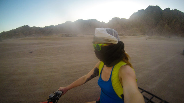 Girls drive quad biike.Desert in Egypt. Sharm el Sheikh. Sand and Sand Borkhan. Rock and sunset. Quad Cycle Travel. Excursion with people.Extreme sports & fun outdoors activities