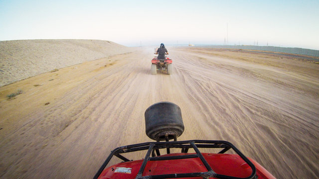 Girls drive quad biike.Desert in Egypt. Sharm el Sheikh. Sand and Sand Borkhan. Rock and sunset. Quad Cycle Travel. Excursion with people.Extreme sports & fun outdoors activities