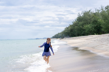 Middle age senior woman is Enjoying and running Summer Vacation on the beach, Thailand.