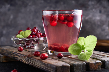 cranberry juice with honey in a cup, cranberries in sugar. On a dark wooden background Copyspace