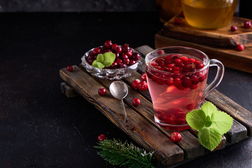 cranberry juice with honey in a cup, cranberries in sugar. On a dark wooden background Copyspace
