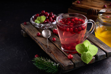 cranberry juice with honey in a cup, cranberries in sugar. On a dark wooden background Copyspace