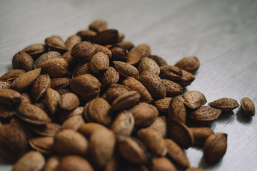 Inshell almonds on wooden background