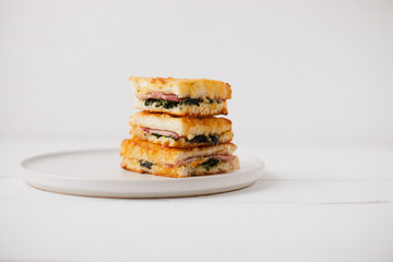 Baked spinach and ham sandwich with sauce.
