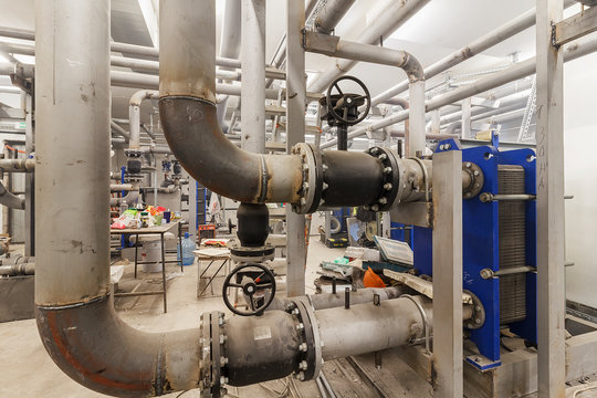 Industrial Factory equipment stainless tubes Food automation. Equipment, cables and piping as found inside of modern industrial power plant. Pipeline assembly. District heating substation. 