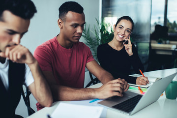 Portrait of successful female entrepreneur enjoying smartphone talking with partner during collaboration process with skilled colleagues, happy woman smiling at camera while calling via phone app