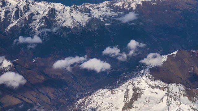 Flying over Alps mountain and clouds above mountain peaks