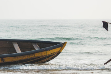 Empty fishing boat with standing flag in ocean