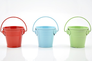 Three metal buckets of different colours with handle © mixeey