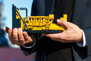 A toy model of a gas generator set is in the male hand.