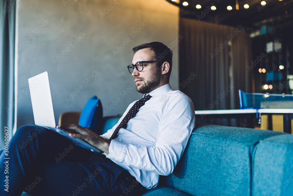 Aufkleber side view of mature businessman in spectacles reading financial news on website using 4g connection 