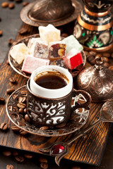 Dark  background  with Turkish coffee cups, aroma beans and eastern sweets