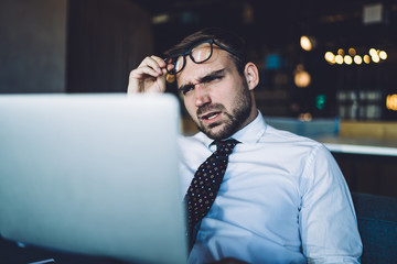 Puzzled businessman with angry expression on face confused with received email from employee with...