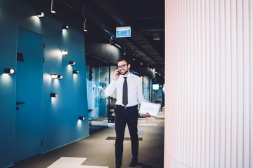 Fototapeta premium Successful experienced lawyer dressed in formal outfit enjoying smartphone conversation with colleague during working day in enterprise corporation, happy man using cellphone for communication