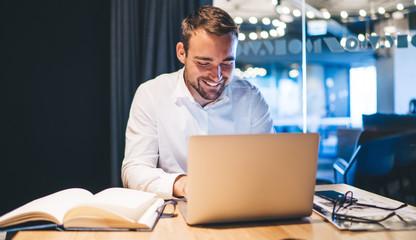 Happy skilled male proud ceo smiling during online communication with colleague connected to free...