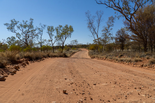 a dry path of sand in the australian outback ends in the desert