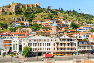 Panorama of the old town on Sololaki hill, crowned with Narikala fortress, the Kura river and cars traffic with blure in Tbilisi, Georgia