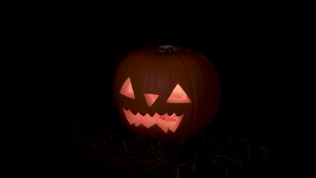 Glowing Halloween pumpkin on the night dark moody style panning and rack focusing camera