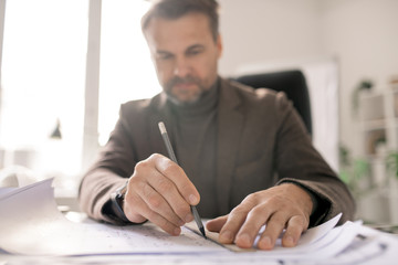 Hands of architect with pencil and ruler drawing line while making sketch