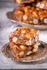 Italian sweet nuts, hazelnuts, almonds, figs, honey dessert over on sugar powder surfase
