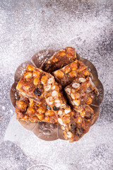 Italian sweet nuts, hazelnuts, almonds, figs, honey dessert over on sugar powder surfase